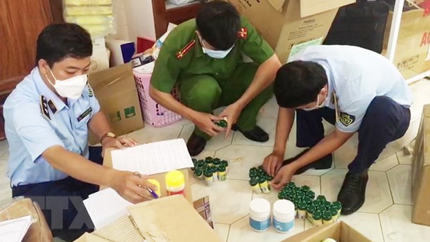 Lực lượng chức năng kiểm đếm số thuốc tạm giữ tại một nhà thuốc. (Ảnh: TTXVN phát)