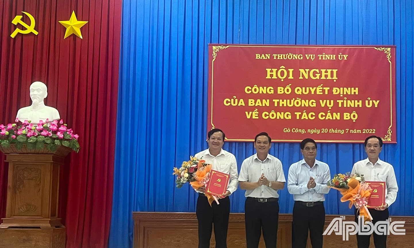 Đồng chí Nguyễn Văn Nhã (thứ hai từ phải qua) và đồng chí Phạm Văn Thanh trao Quyết định, tặng hoa cho 2 đồng chí Nguyễn Hữu Lợi (bìa trái) và Nguyễn Kiên Cường (bìa phải).