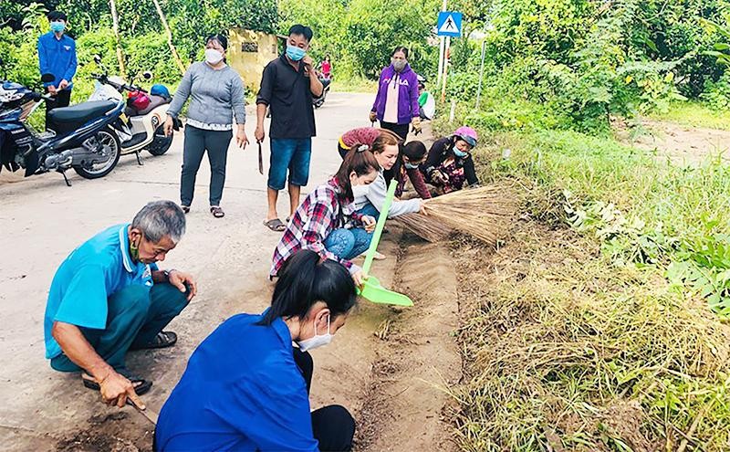 Người dân thành phố Cao Lãnh, tỉnh Đồng Tháp vệ sinh môi trường, phát quang bờ bụi chống dịch bệnh. (Ảnh HẢI DƯƠNG)