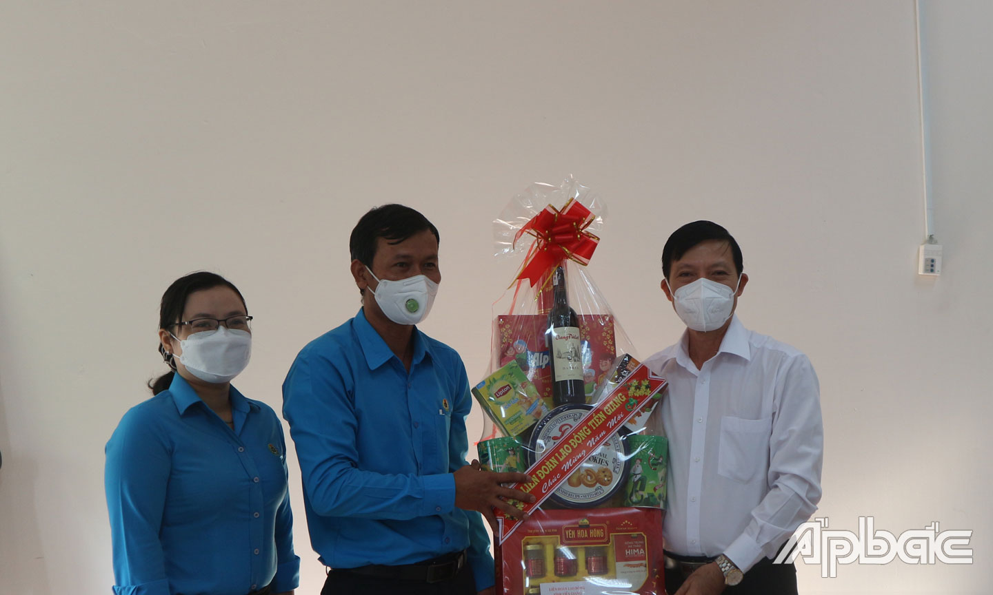 Anh Việt (bìa phải) nhận quà chúc Tết từ lãnh đạo Liên đoàn Lao động tỉnh Tiền Giang. 