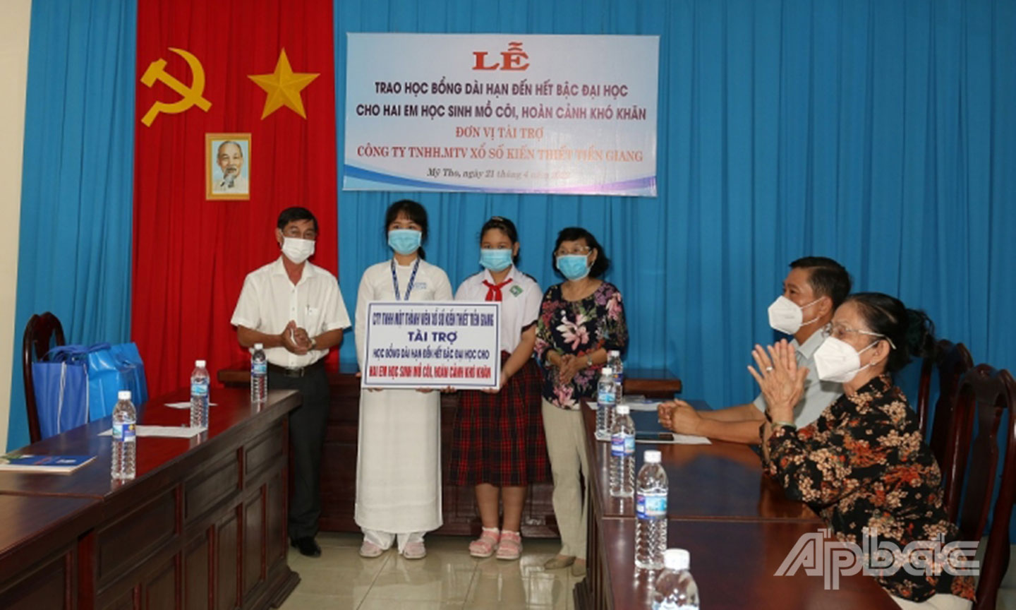 Ông Trần Văn An, Giám đốc Công ty TNHH MTV Xổ số kiến thiết Tiền Giang trao học bổng cho học sinh có hoàn cảnh khó khăn. Ảnh: X.U