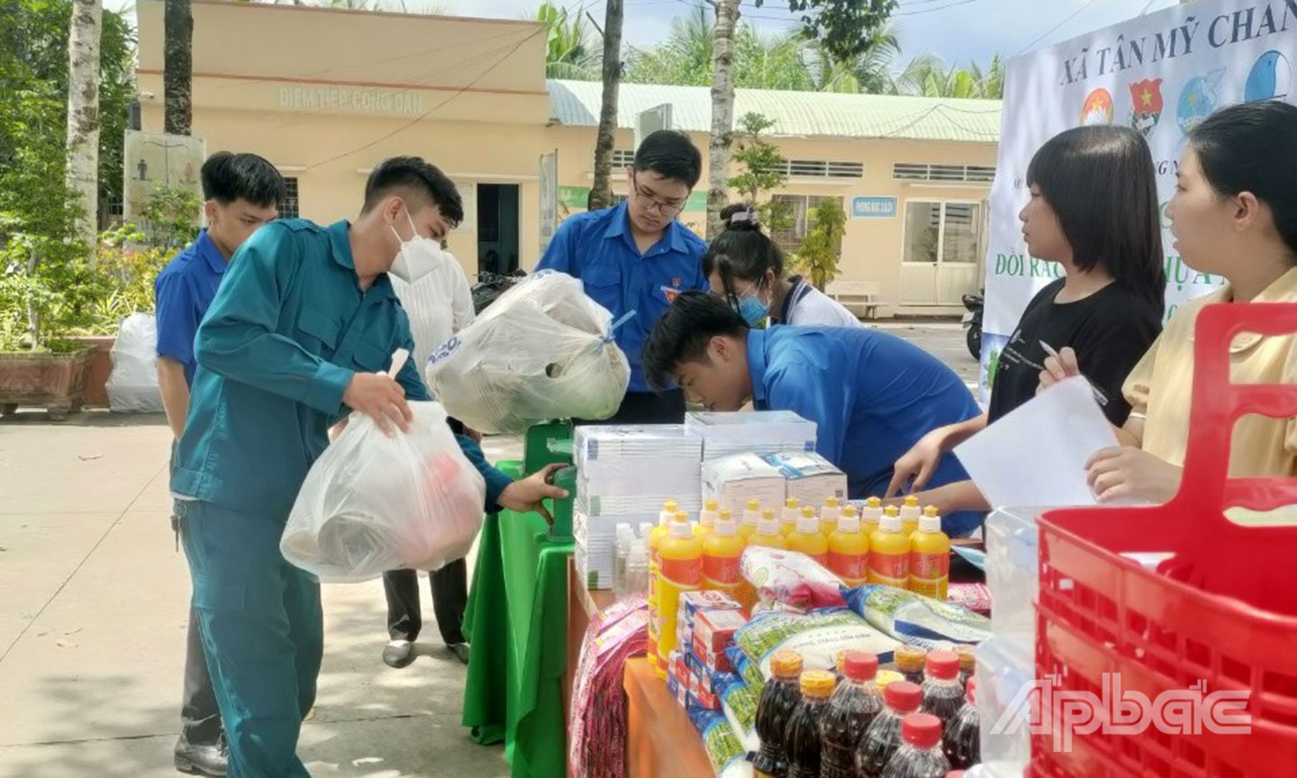 Người dân mang rác thải nhựa đến đổi quà tại Chương trình ”Đổi rác tái chế nhận quà” diễn ra ở UBND xã Tân Mỹ Chánh.