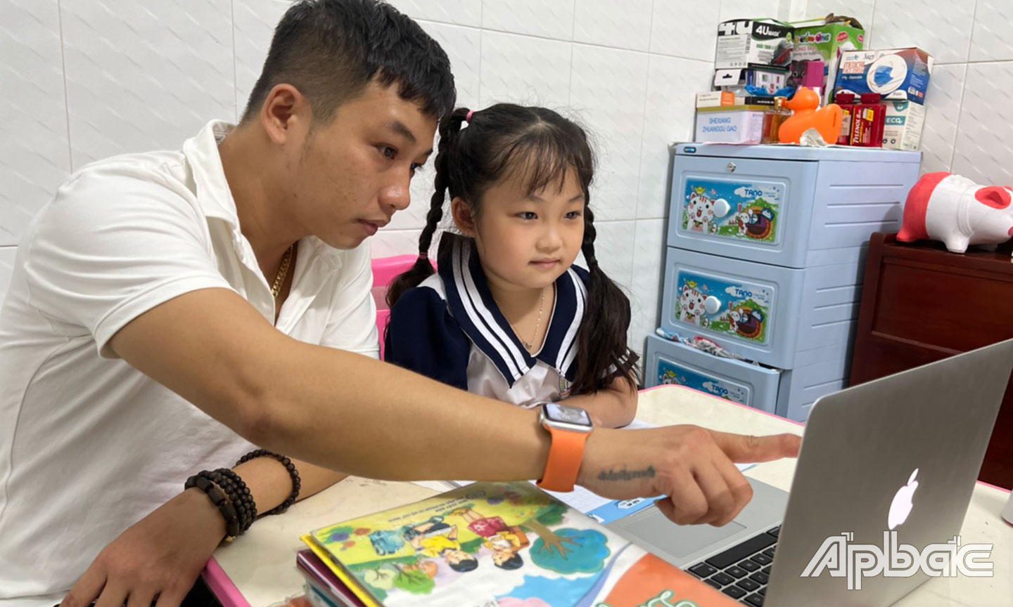 Phụ huynh hỗ trợ con trẻ học trực tuyến trong thời điểm dịch Covid-19 bùng phát không thể đến trường. 		Ảnh: P. CÔNG