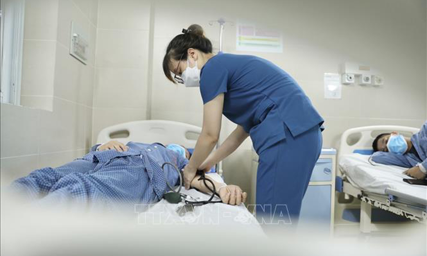 Điều dưỡng chăm sóc bệnh nhân đang điều trị cúm A tại bệnh viện Thanh Nhàn. Ảnh: Minh Quyết/TTXVN