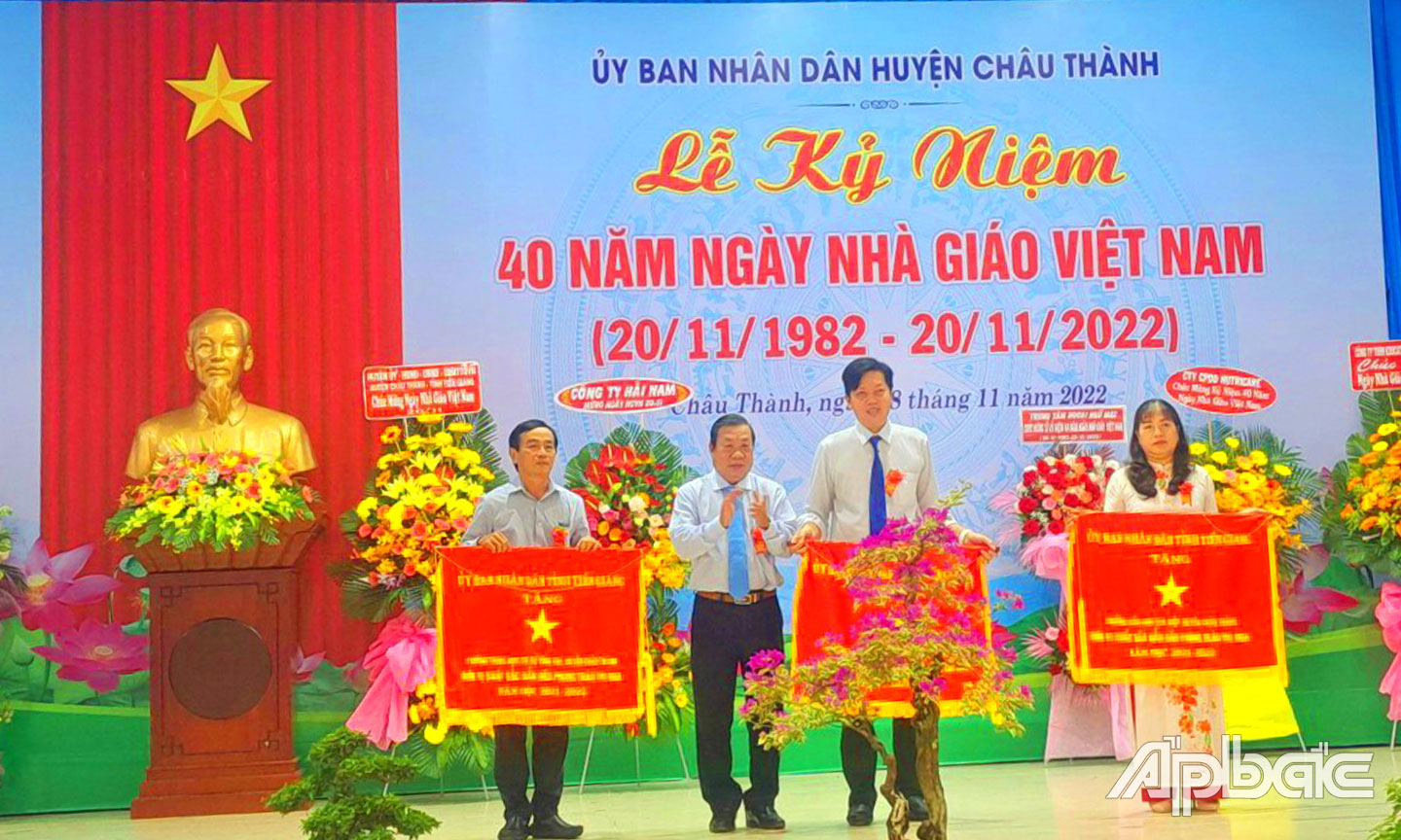 Đồng chí Nguyễn Ngọc Trầm, Ủy viên Ban Thường vụ, Chủ nhiệm Ủy ban Kiểm tra Tỉnh ủy trao Cờ thi đua của UBND tỉnh Tiền Giang cho Trường THCS Vĩnh Kim (bìa trái).