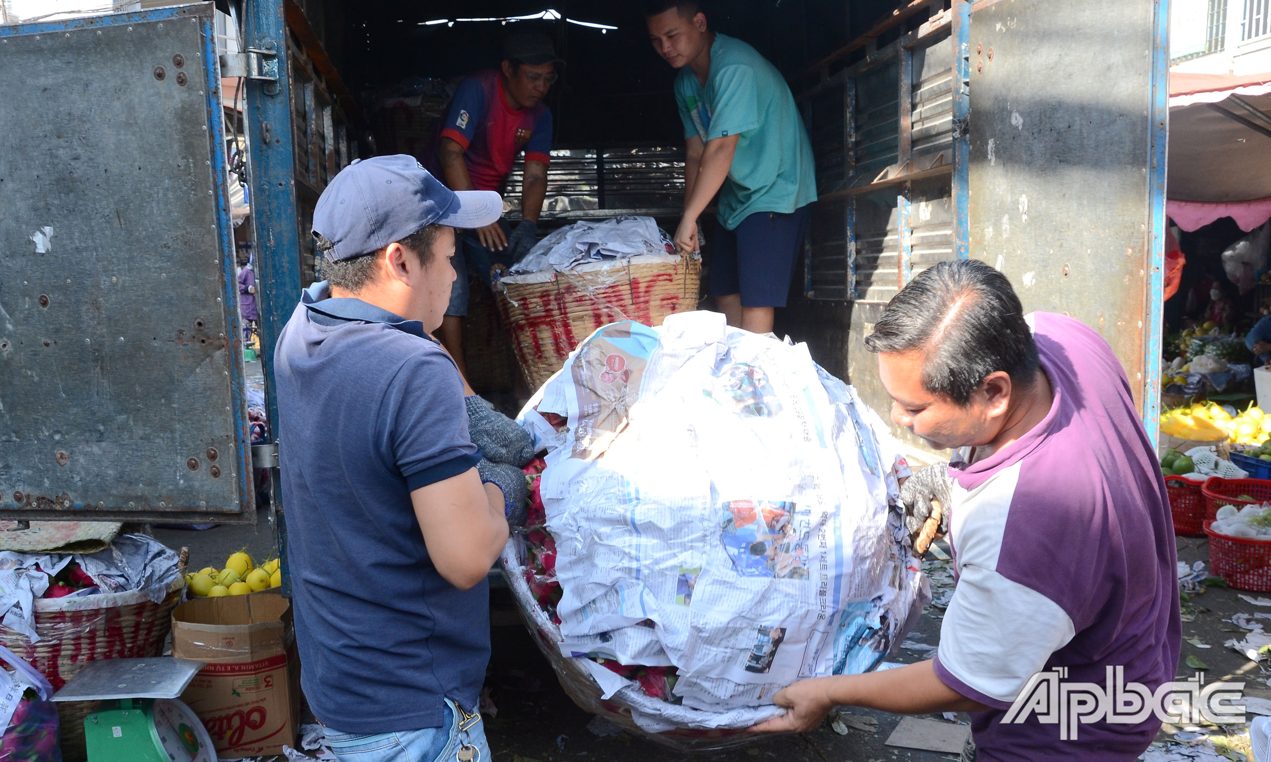 Nhân công vận chuyển trái cây xuống vựa.