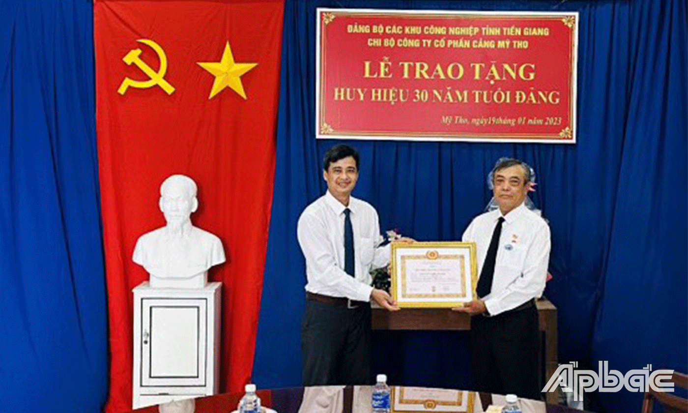 Đồng chí Trần Minh Diễn, Bí thư Đảng ủy các Khu công nghiệp (bên trái) trao Huy hiệu Đảng cho đồng chí Nguyễn Trí Thanh.