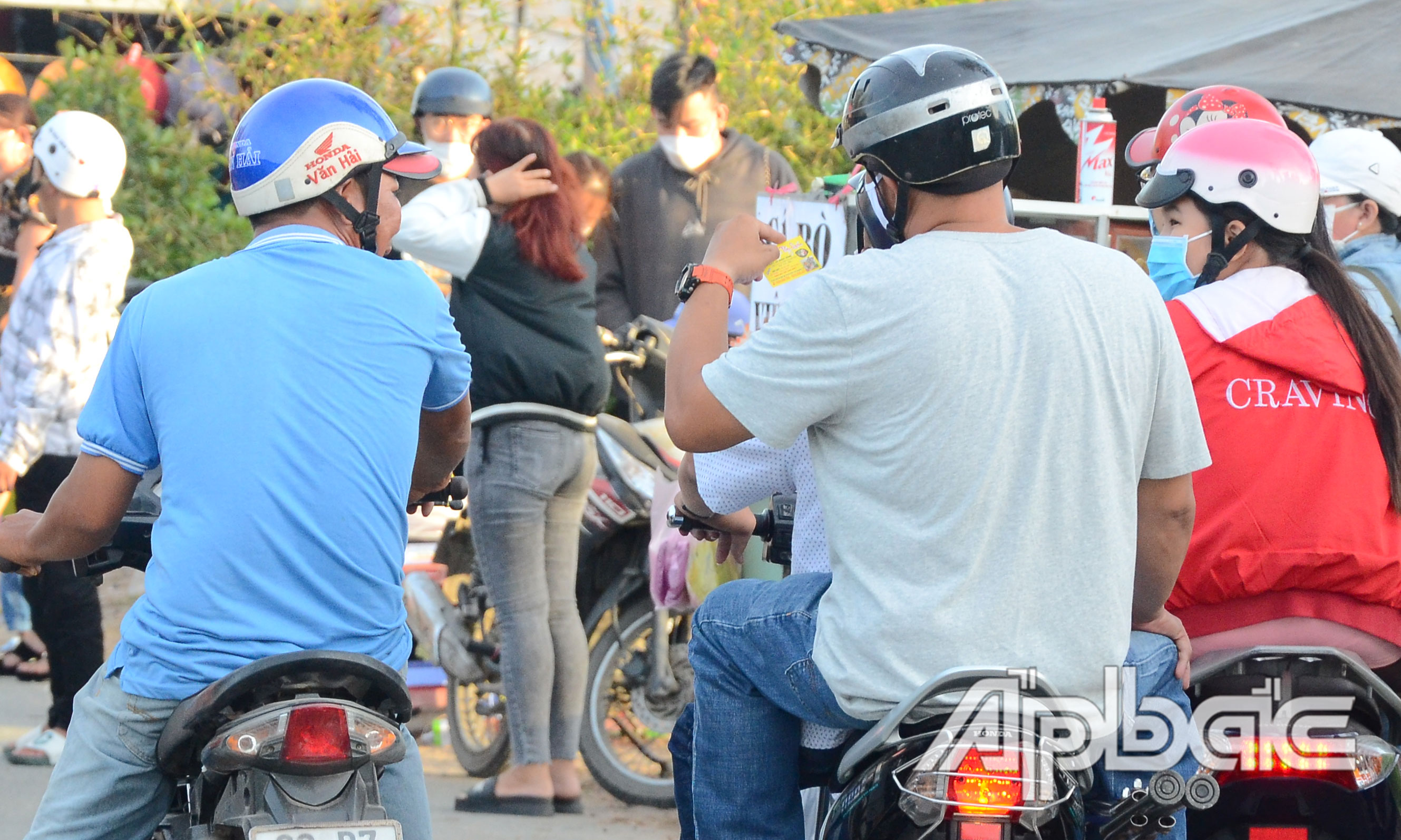 Đưa danh thiếp quán ăn để mời chào du khách đến ăn.