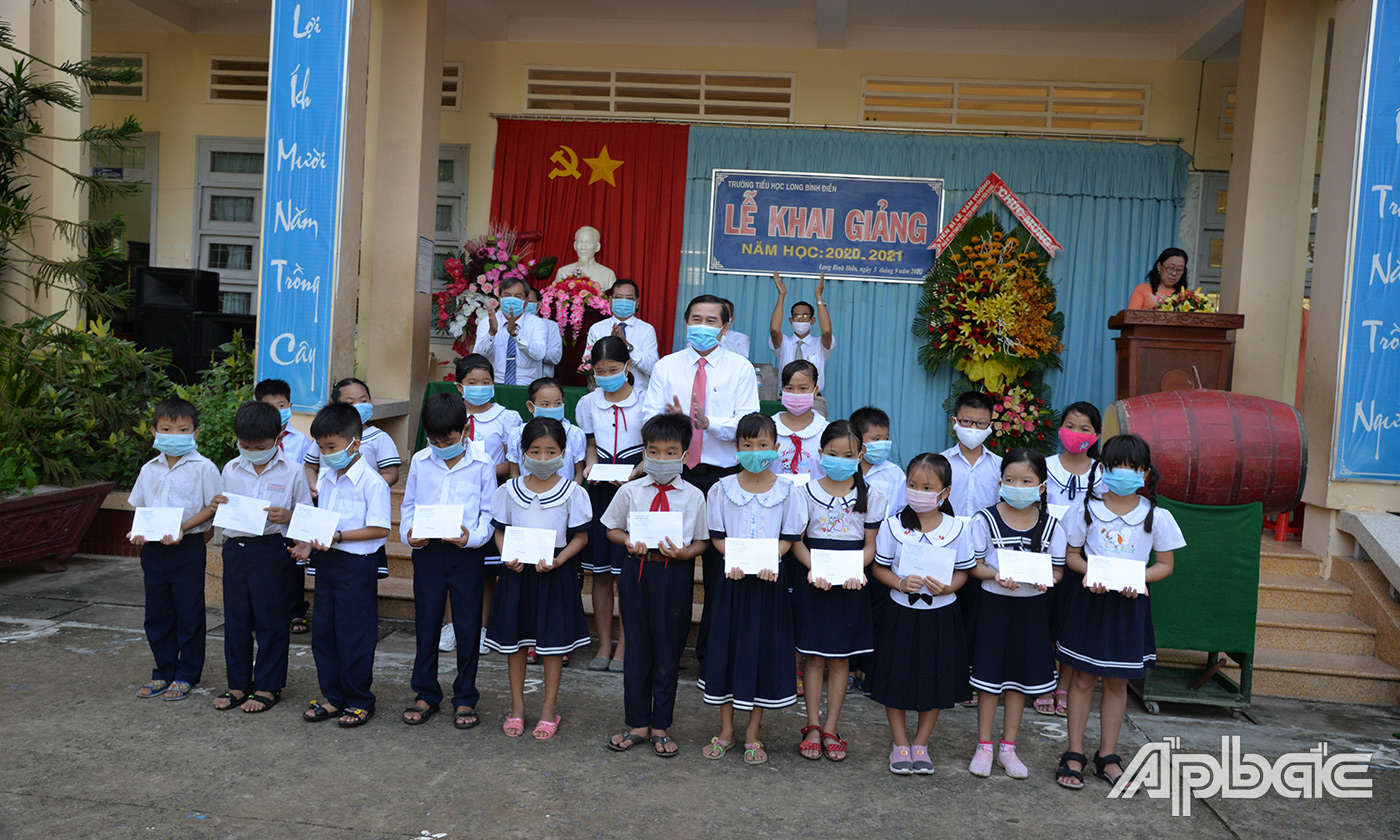 Đồng chí Lê Văn Hưởng tặng học bổng cho học sinh vượt khó học tốt của Trường Tiểu học Long Bình Điền.