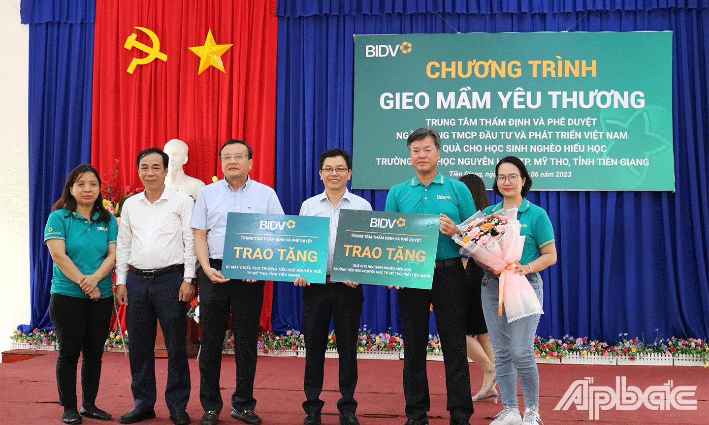 Ông Võ Thanh Trường Chủ tịch Công đoàn Trung tâm Thẩm định và phê duyệt BIDV trao bảng tượng trưng tặng quà cho học sinh khó khăn và máy chiếu cho nhà trường