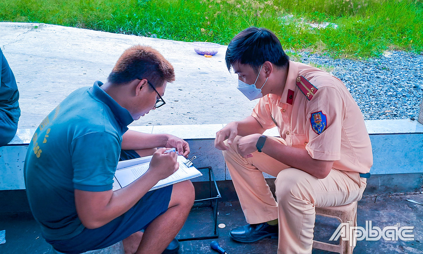 Cán bộ CSGT cho chủ cơ sở ký cam kết.