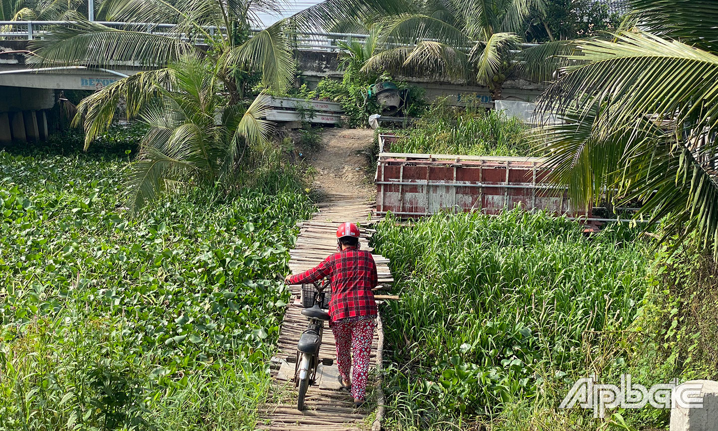 Người dân qua lại cầu tạm rất khó khăn và nguy hiểm.