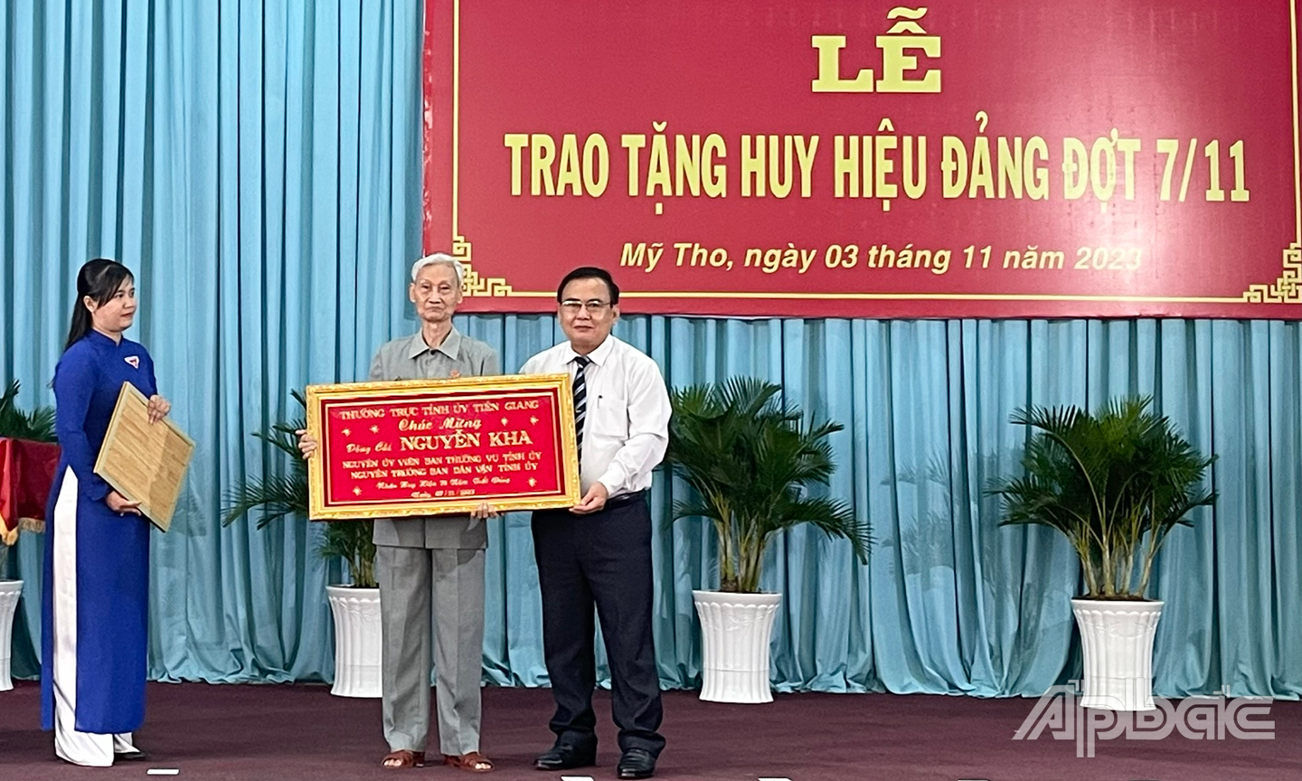 Đồng chí Võ Văn Bình, Phó Bí thư Thường trực Tỉnh ủy, Chủ tịch HĐND tỉnh Tiền Giang trao Huy hiệu 75 năm tuổi Đảng tặng đảng viên cao niên Nguyễn Kha ( Đảng bộ phường 4, TP. Mỹ Tho ).