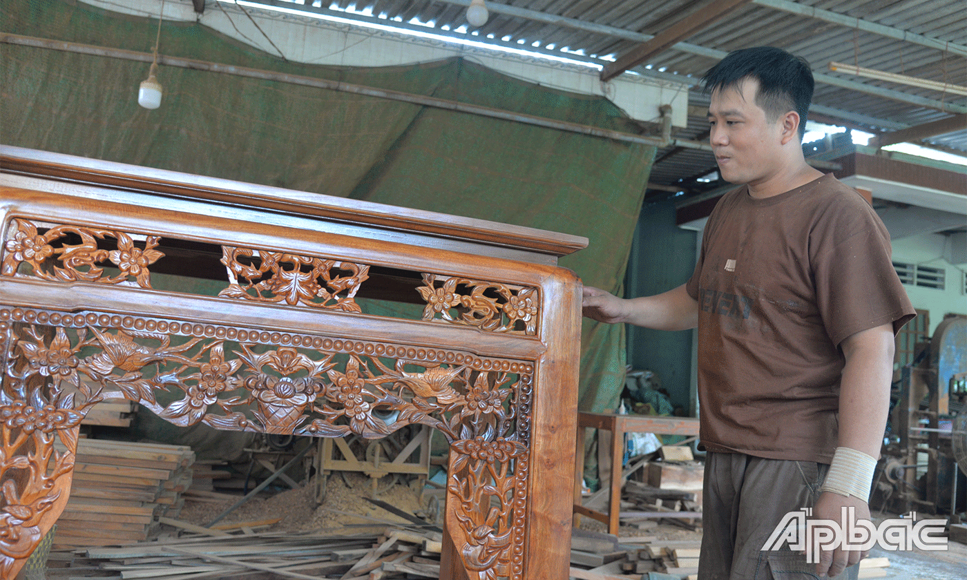 Anh Phan Thế Vinh bên sản phẩm của mình làm ra.