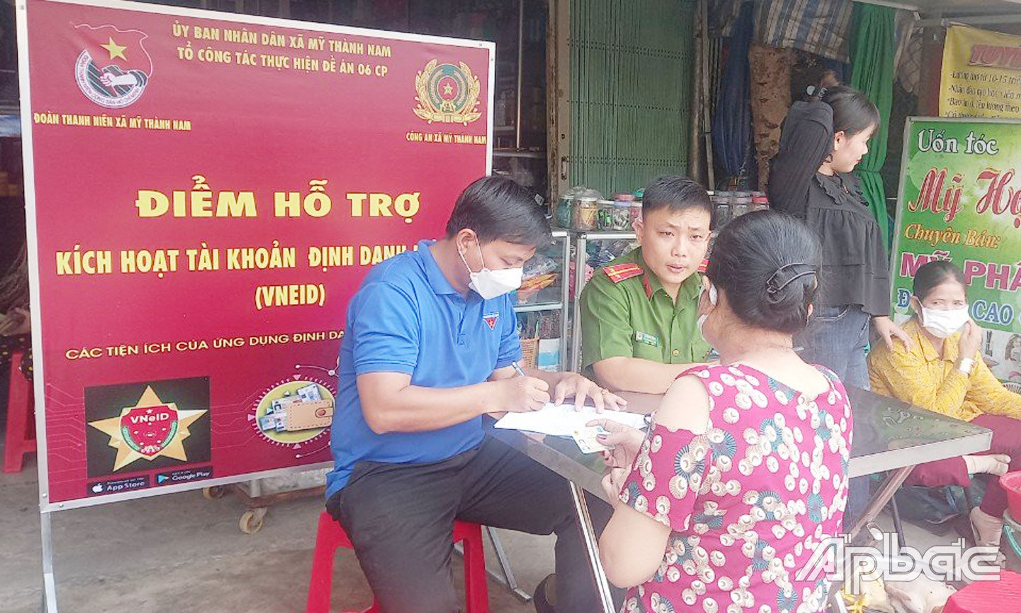 Thượng úy Lê Quang Thịnh hỗ trợ người dân thực hiện cài đặt định danh điện tử VNeID.