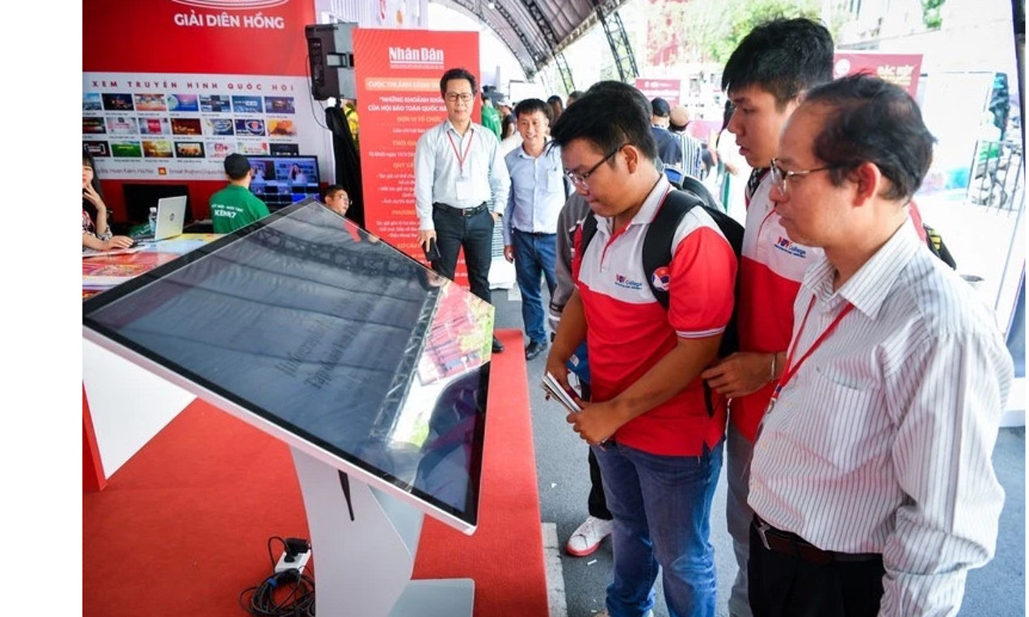 Bạn đọc tham quan, giao lưu tại gian trưng bày của Báo Nhân Dân trong Hội Báo toàn quốc 2024. Ảnh: THÀNH ĐẠT