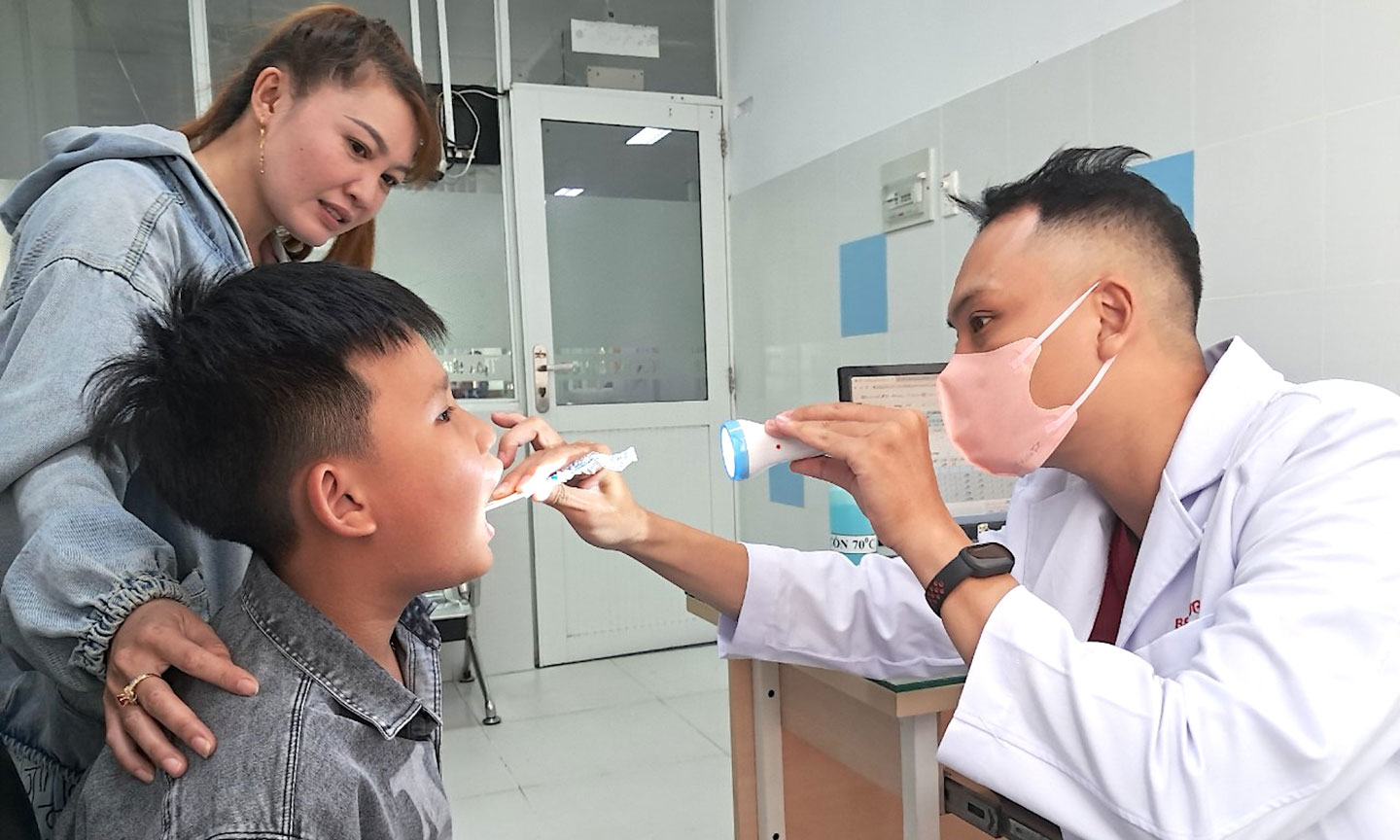 BS Đăng Nhật, khoa Khám bệnh ngoại trú, Bệnh viện Nhi đồng 2, TPHCM thăm khám cho bệnh nhi. Ảnh: QUANG HUY 