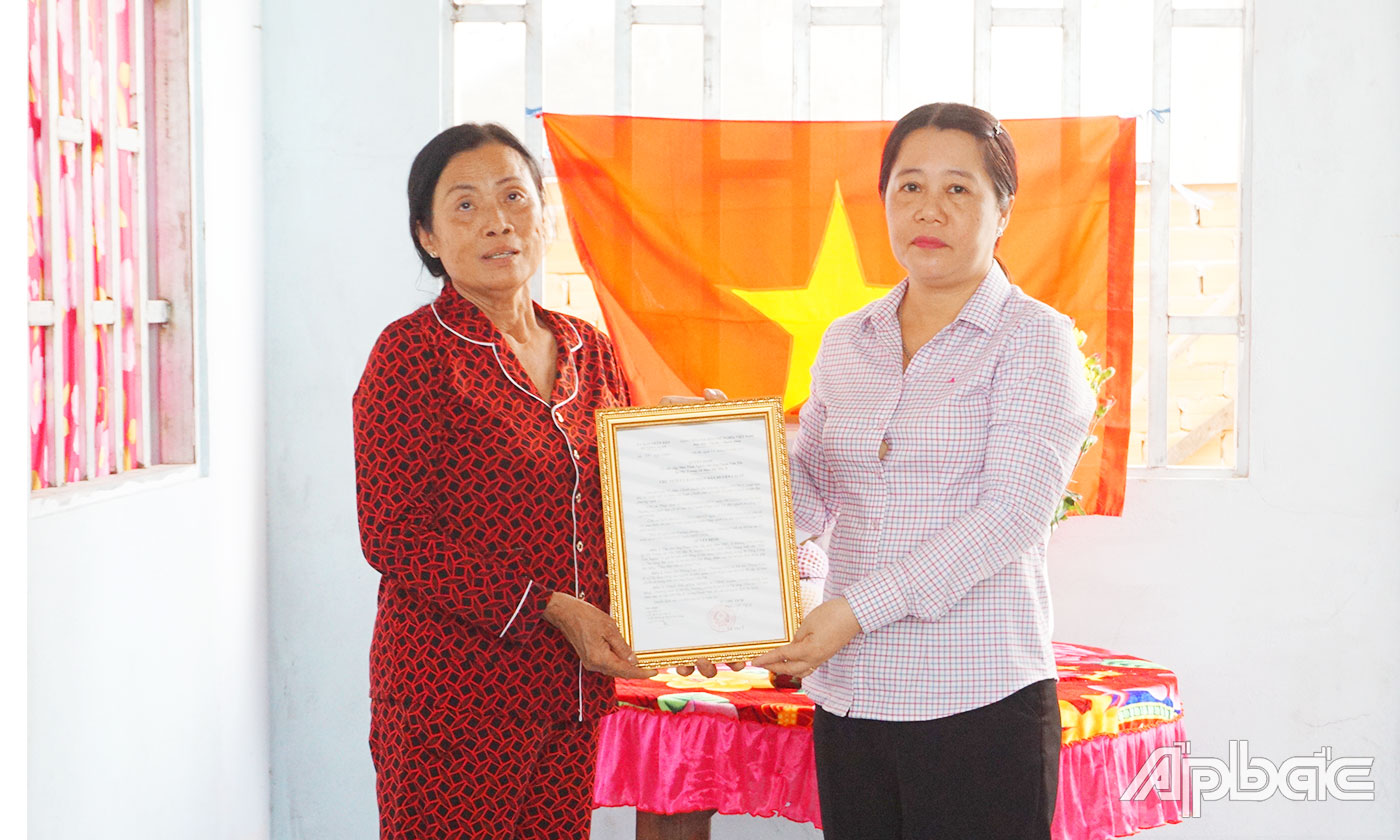 Vợ ông Phạm Văn Tất nhận Quyết định bàn giao nhà.