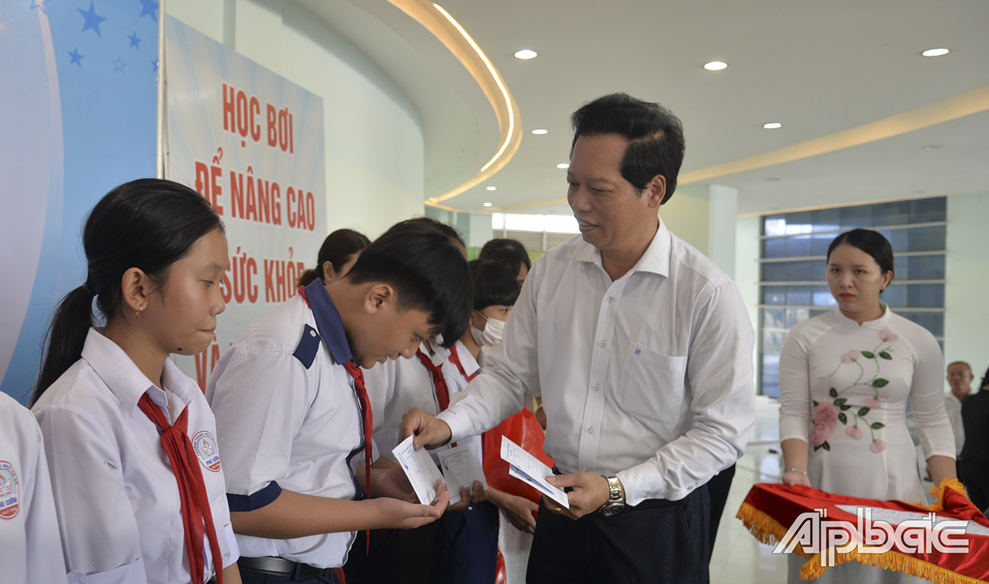 Đồng chí Nguyễn Thành Diệu, Tỉnh ủy viên, Phó Chủ tịch UBND tỉnh, Chủ tịch Hội đồng bảo vệ, chăm sóc trẻ em tỉnh Tiền Giang và đồng chí Lý Văn Cẩm, Tỉnh ủy viên, Giám đốc Sở LĐ-TB&XH, Phó Chủ tịch Thường trực Hội đồng bảo vệ, chăm sóc trẻ em tỉnh Tiền Giang trao học bổng cho học sinh vượt khó
