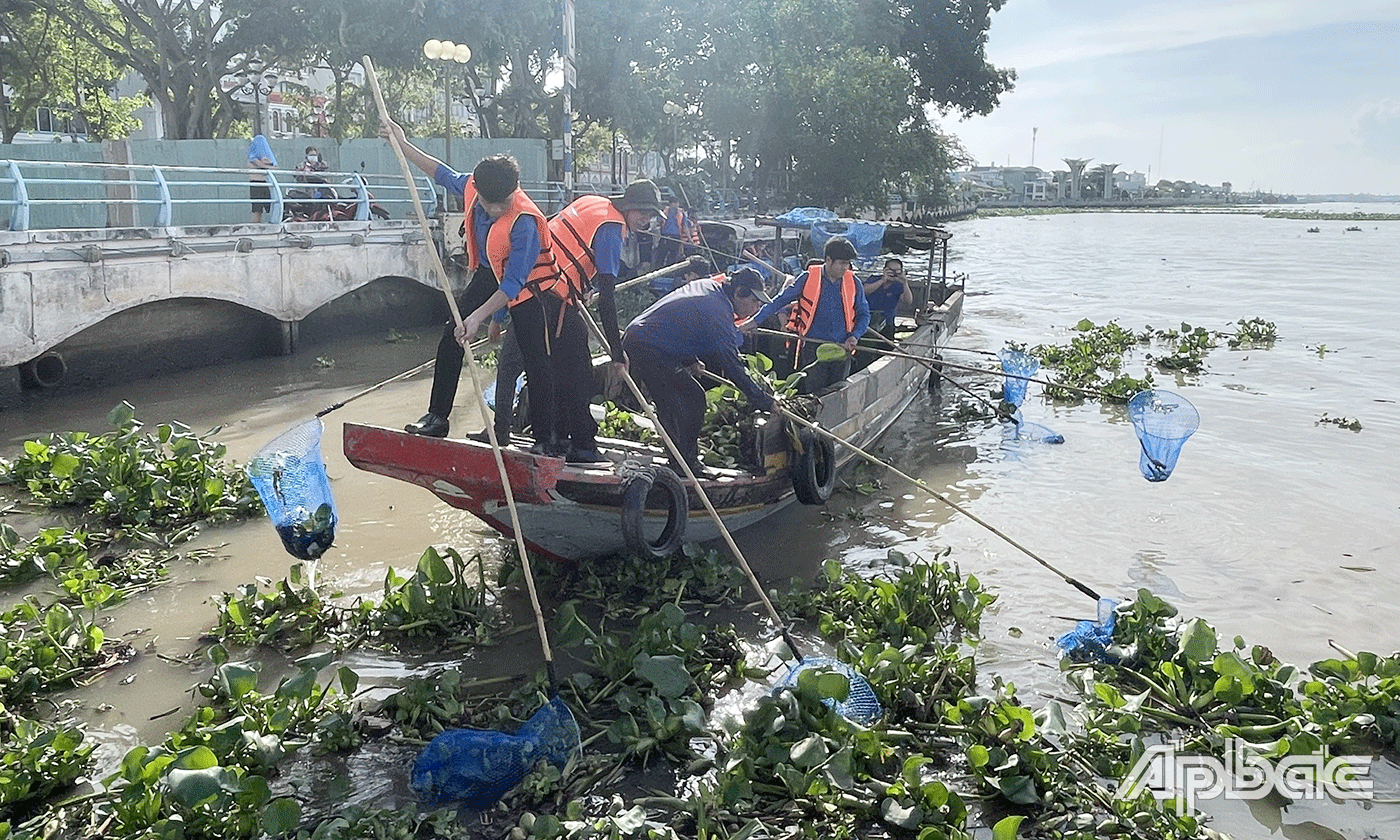 Đoàn viên thanh niên TP. Mỹ Tho và công nhân Công ty TNHH MTV Công trình đô thị Mỹ Tho vớt rác trên sông Tiền.