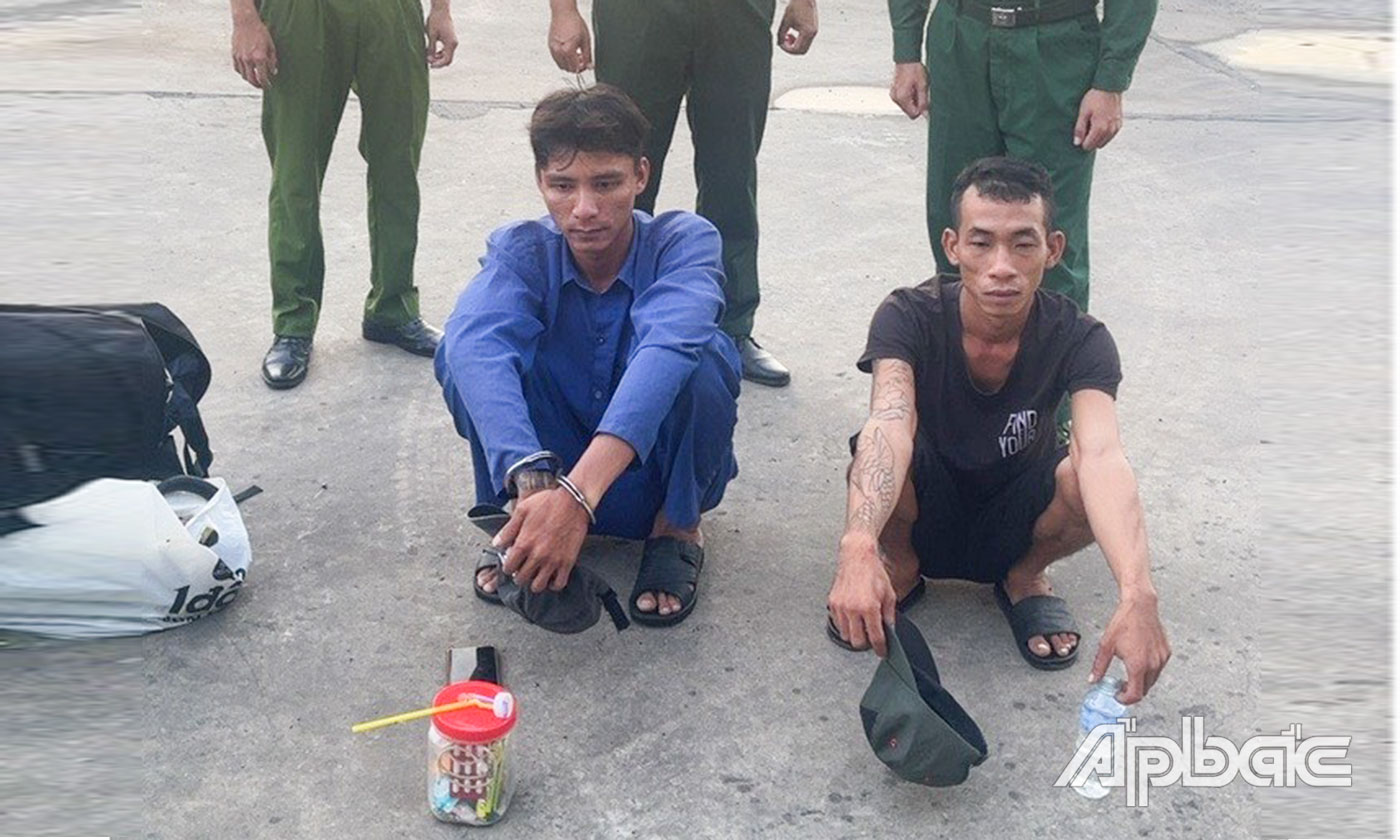 Đối tượng Bùi Minh Phúc (mặc áo xanh ngồi bên trái) và đối tượng Mai Thanh Tùng bị lực lượng chức năng bắt quả tang cùng với tang vật.