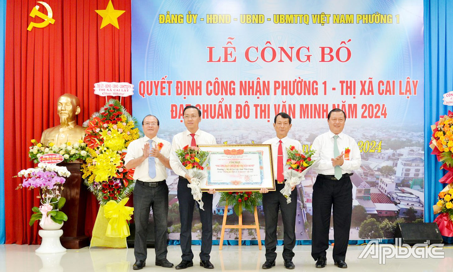 Đồng chí Phan Phùng Phú, Ủy viên Ban Thường vụ Tỉnh ủy, Bí thư Thị ủy, Chủ tịch HĐND TX. Cai Lậy và đồng chí Trần Văn Thức, Chủ tịch UBND TX. Cai Lậy trao Quyết định công nhận “Phường đạt chuẩn đô thị văn minh” và tặng hoa chúc mừng phường 1.