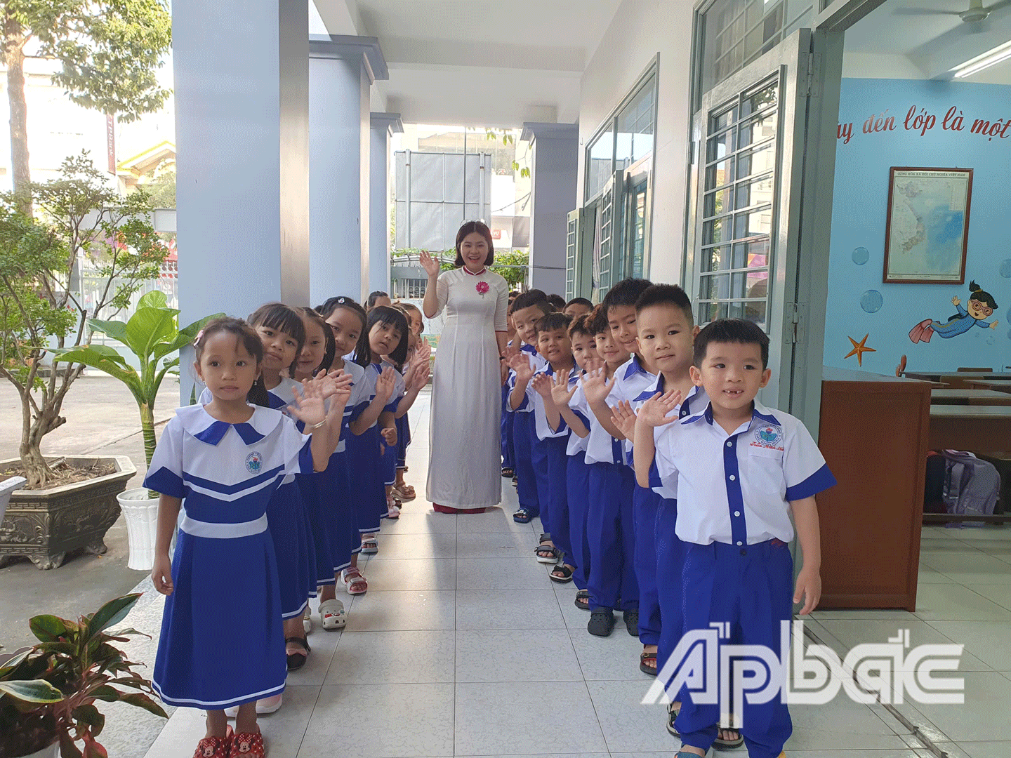 Học sinh lớp được giáo viên chủ nhiệm dẫn tham quan trường học. 