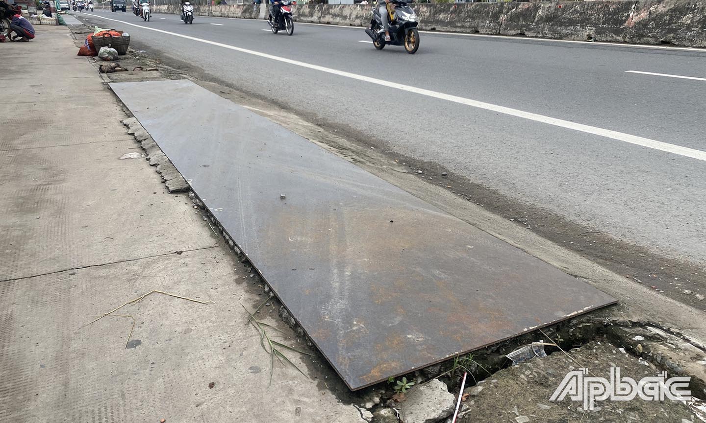 Người dân dùng tấm sắt để che chắn cống.