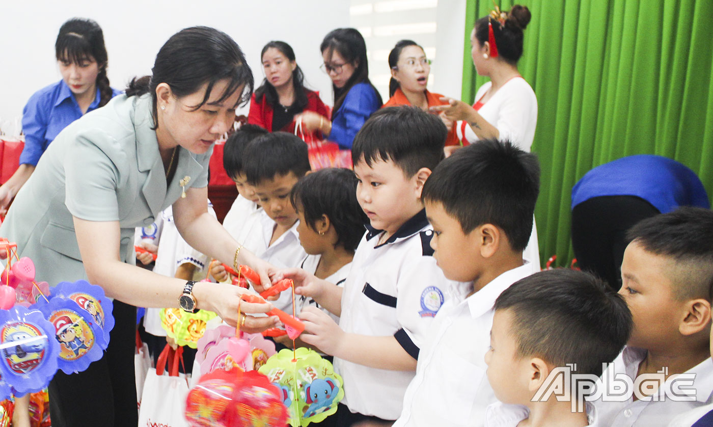 Phó Giám đốc Sở Lao động-Thương binh và Xã hội Nguyễn Thị Mỹ Nương trao quà cho trẻ em huyện Chợ Gạo.