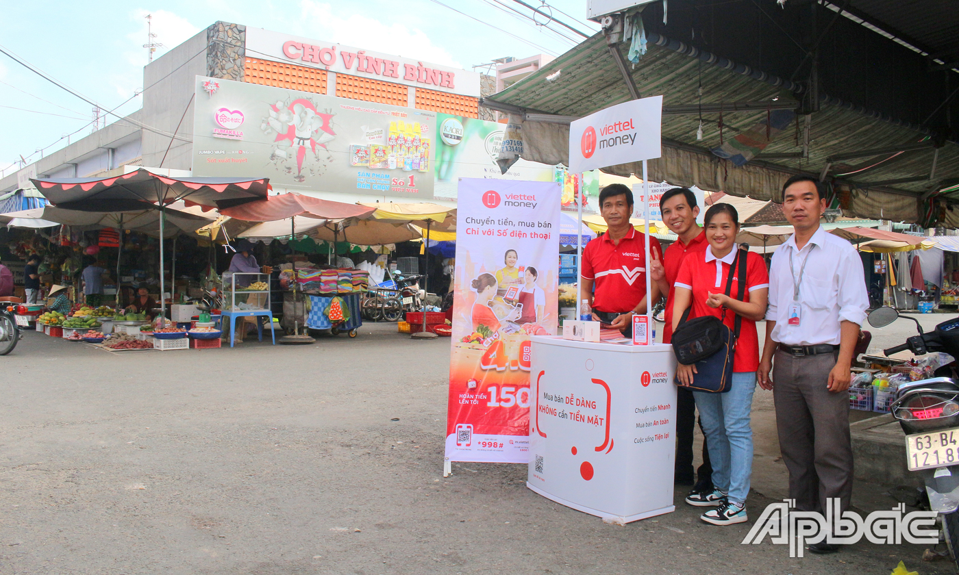Viettel Tiền Giang hỗ trợ người dân cài đặt, sử dụng thanh toán không dùng tiền mặt tại chợ Vĩnh Bình (thị trấn Vĩnh Bình, huyện Gò Công Tây).