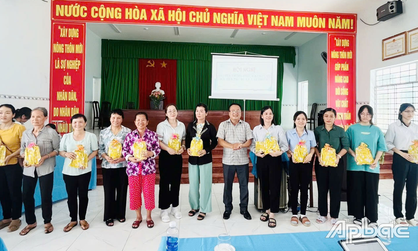 Hội viên Hội Liên hiệp Phụ nữ xã Tân Phước, huyện Gò Công Đông nhận quà lưu niệm khi đăng ký tham gia BHXH tự nguyện tại hội nghị.