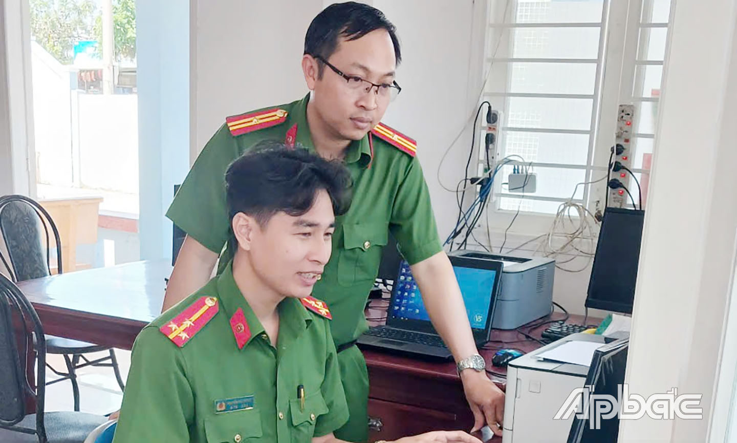 (Cán bộ phòng PC06 - Công an tỉnh Tiền Giang hướng dẫn Công an xã giải quyết cư trú trên hệ thống Cơ sở dữ liệu quốc gia về dân cư. Ảnh: Thanh Hiếu)