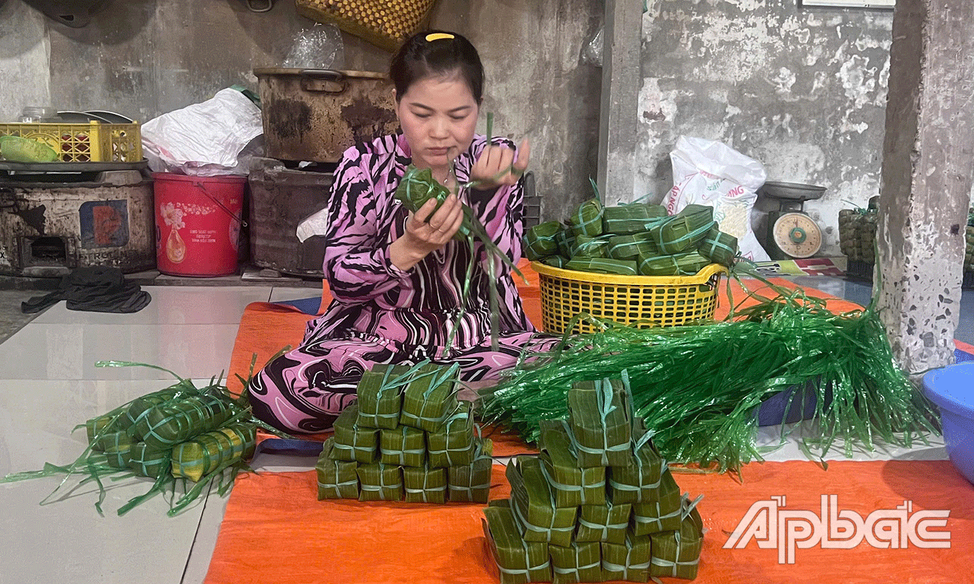 Những đôi tay thoăn thoắt, nhanh nhẹn và khéo léo gói từng đòn bánh tét.