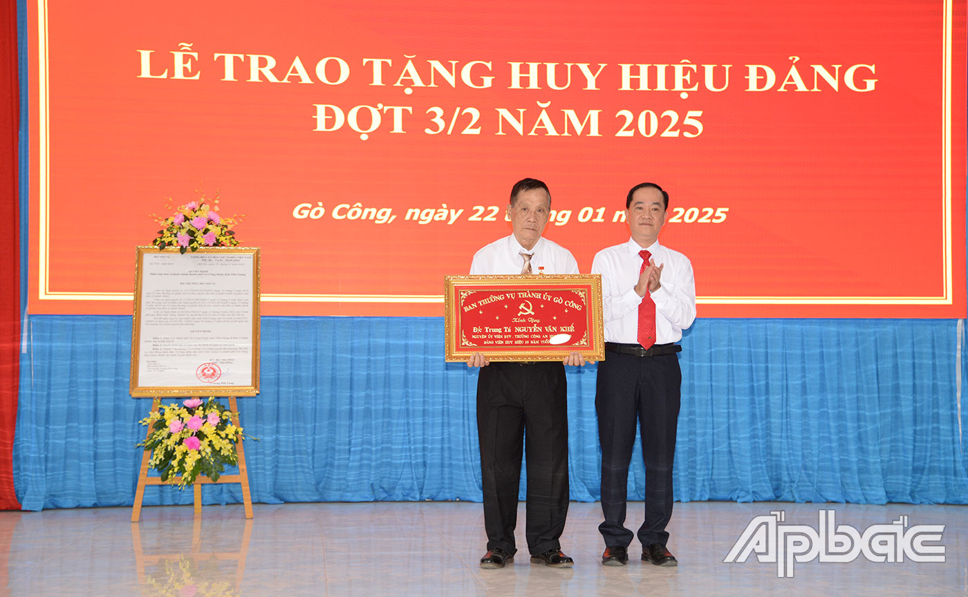 Đồng chí Nguyễn Kiên Cường trao Huy hiệu Đảng cho đảng viên.