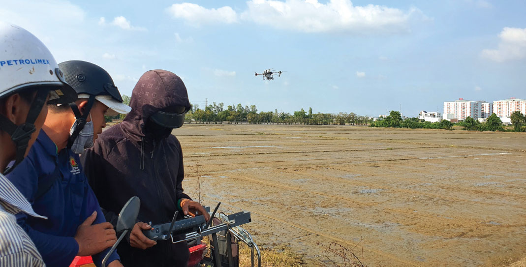 Nông dân đồng bằng sông Cửu Long dùng máy bay không người lái bón phân cho lúa. Ảnh: N.K