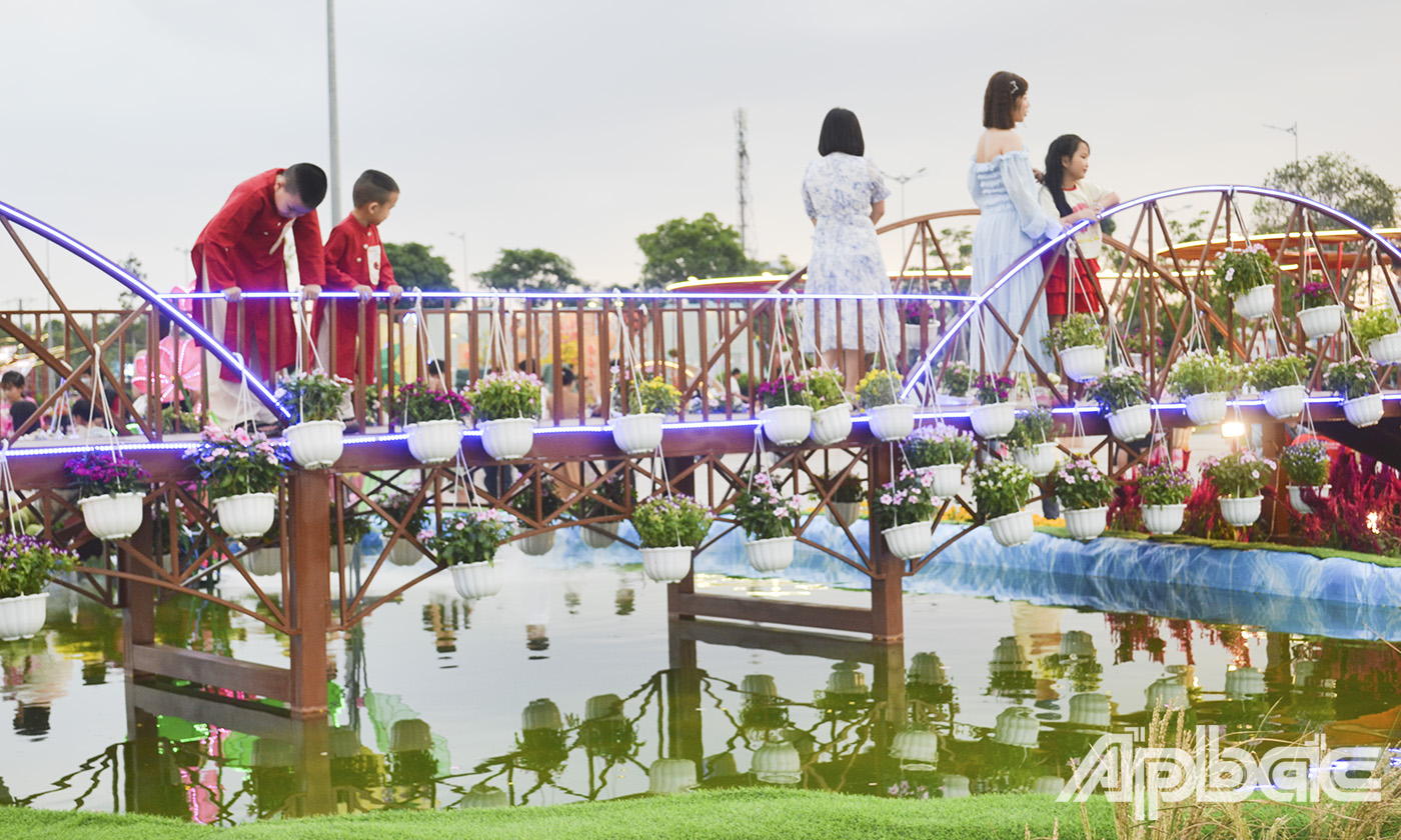 Người dân chụp ảnh bên các tiểu cảnh của đường hoa.