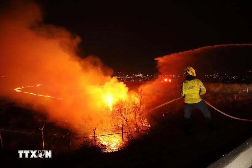 Lính cứu hỏa nỗ lực dập lửa cháy rừng tại Castaic, Los Angeles, California (Mỹ), ngày 22/1/2025. Ảnh: THX/TTXVN
