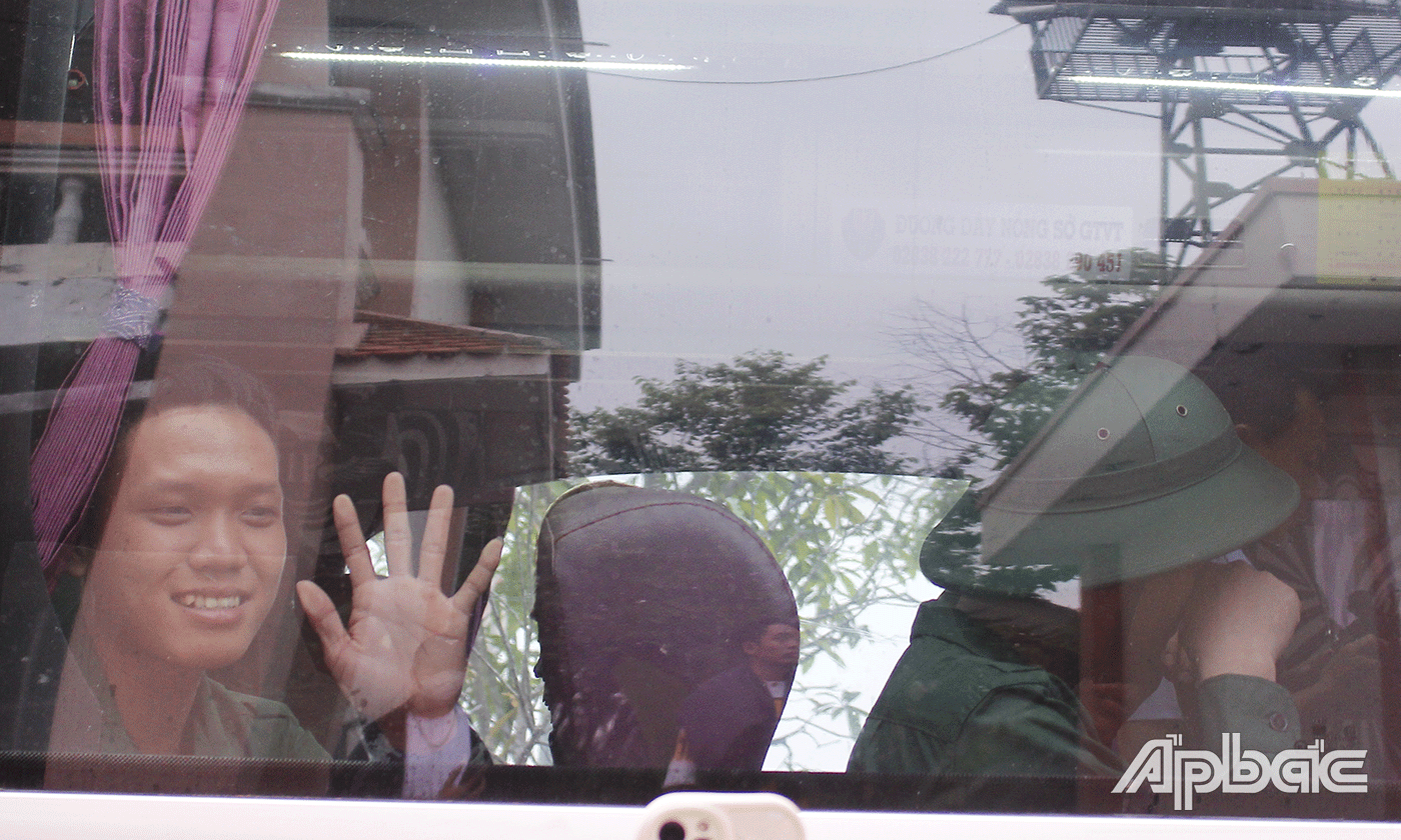   Tân binh vẫy tay chào người thân lên đường nhập ngũ.