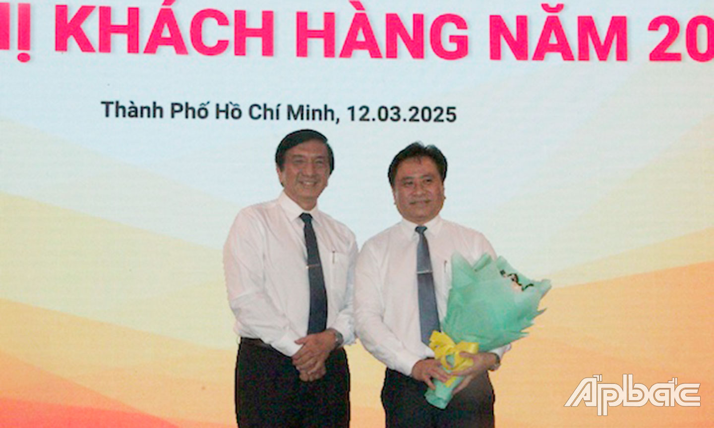 Ông Nguyễn Minh Hiếu (trái), Chủ tịch Công ty TNHH MTV Xổ số kiến thiết Tiền Giang tặng hoa và cảm ơn Trần Văn Dũng, Phó Chủ tịch Thường trực UBND tỉnh Tiền Giang