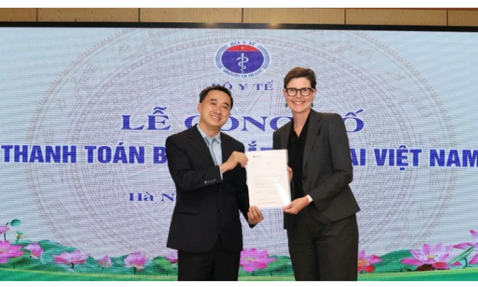 Trưởng đại diện Tổ chức Y tế Thế giới tại Việt Nam (bên phải) trao chứng nhận thanh toán thành công bệnh mắt hột tại Việt Nam cho Thứ trưởng Y tế Trần Văn Thuấn.