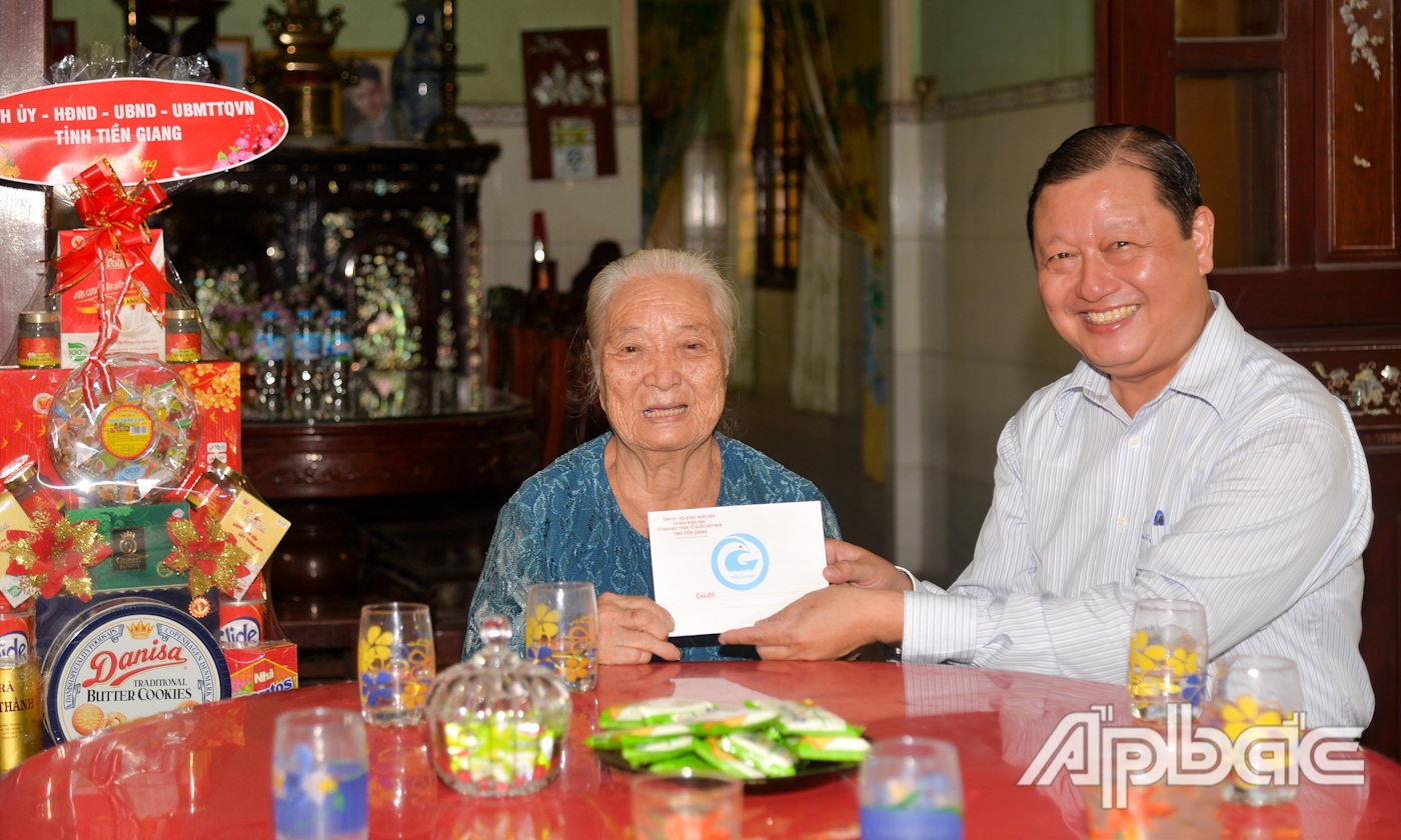 Đồng chí Phan Phùng Phú trao quà tặng bà Phan Thị Quyến (vợ liệt sĩ).