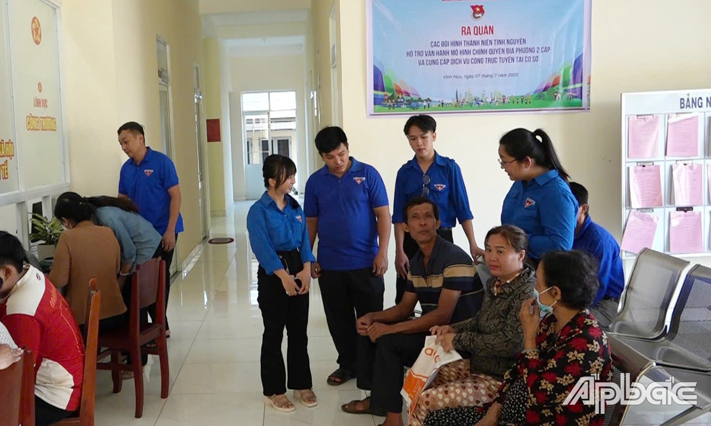Đoàn viên thanh niên xã Vĩnh Hựu hướng dẫn người dân làm thủ tục