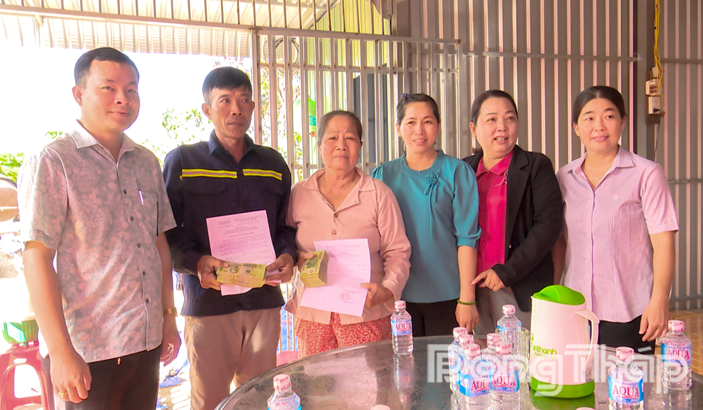 Ông Nguyễn Văn Công - Phó Chủ tịch UBND xã Bình Thành trao tiền hỗ trợ đột xuất cho 2 hộ gia đình