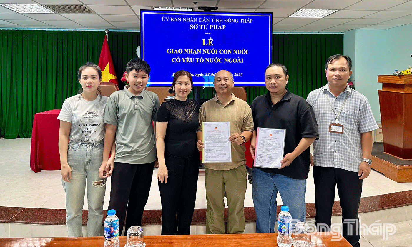 Em Đỗ Nguyễn Bảo Long cùng cha mẹ ruột và cha mẹ nuôi.