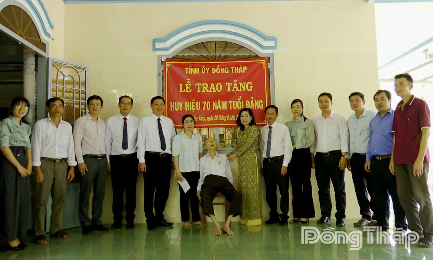 Đồng chí Châu Thị Mỹ Phương và lãnh đạo xã Tân Thới chụp ảnh lưu niệm cùng gia đình đảng viên Nguyễn Văn Tất.