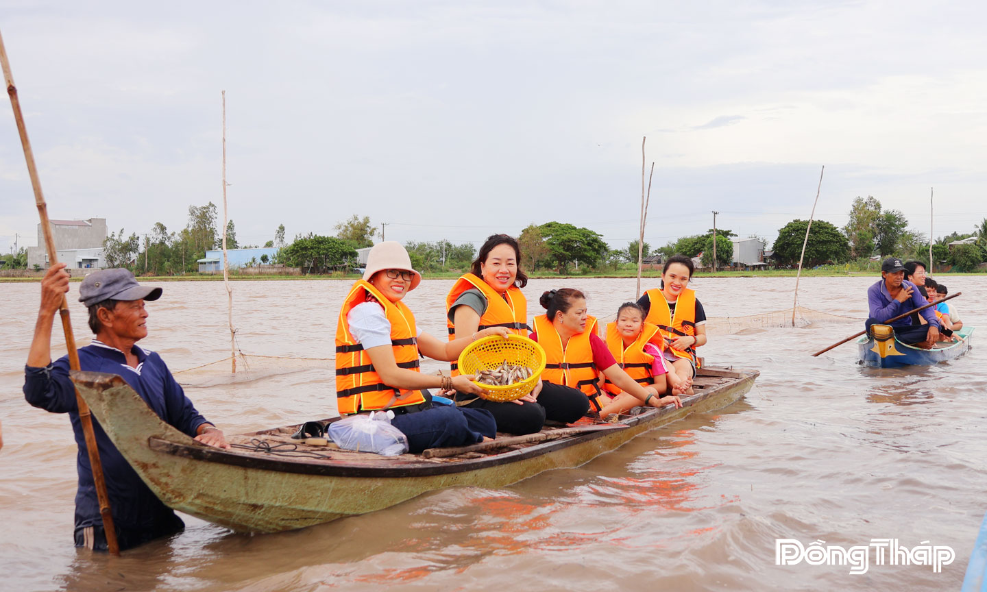 Khách du lịch thích thú trải nghiệm mùa nước nổi tại khu vực nuôi trữ cá đồng  ở ấp Giồng Bàng, xã Thường Phước.