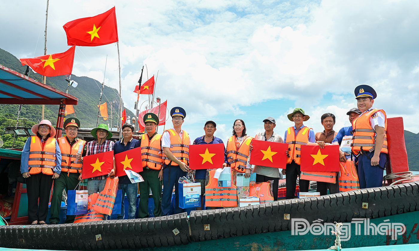 Trao tặng cờ Tổ quốc và nhu yếu phẩm cho các tàu cá đang hoạt động trên biển.