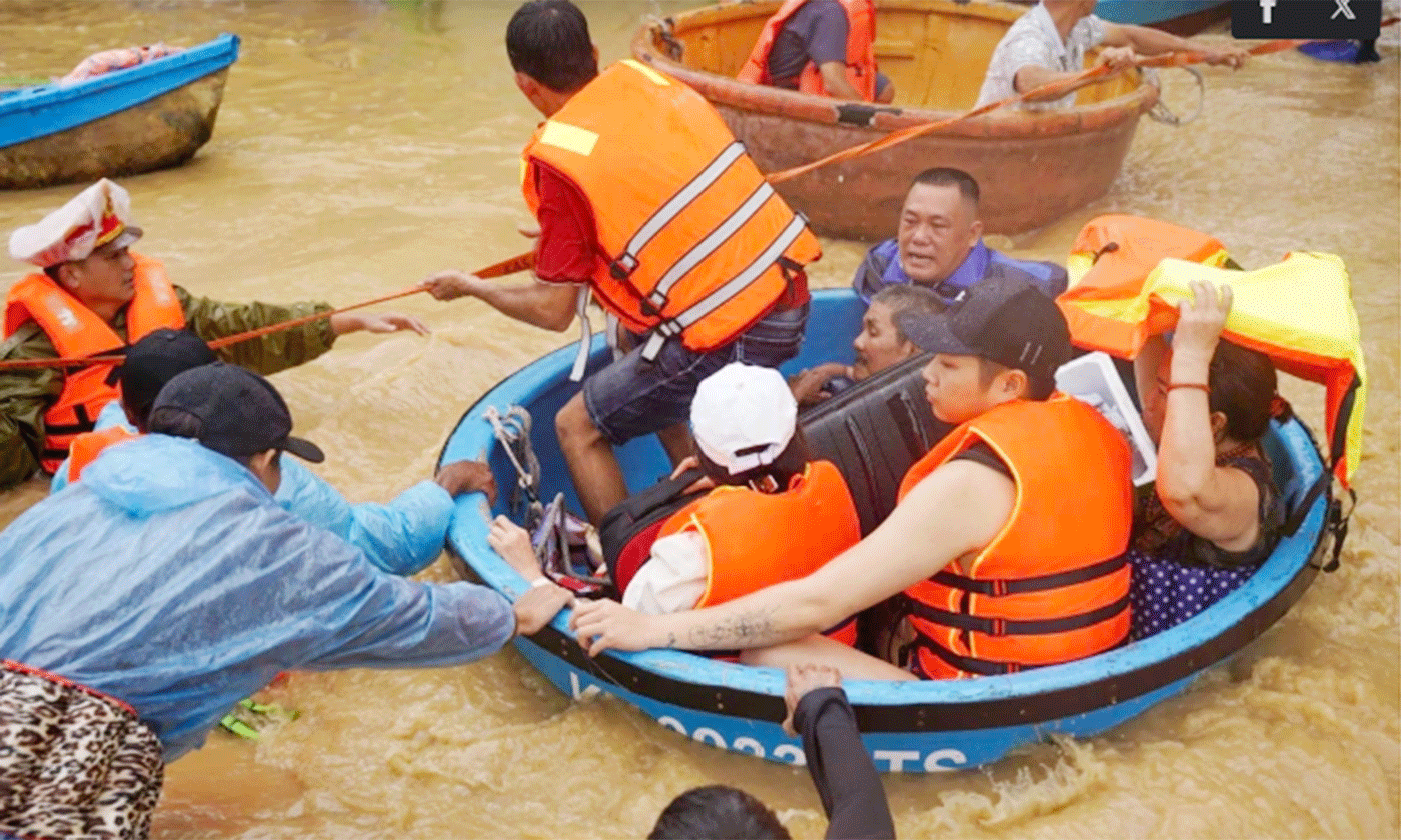 Các đội cứu hộ phường Tây Nha Trang, Khánh Hòa dùng thuyền thúng chở người, tài sản đến nơi an toàn. Nước lũ chảy xiết trên đường khiến việc cứu hộ gặp khó khăn. Ảnh: Bùi Toàn