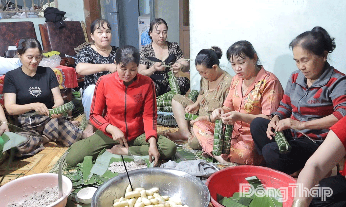 Phụ nữ xã Tân Thuận Bình nhanh tay gói những đòn bánh tét.