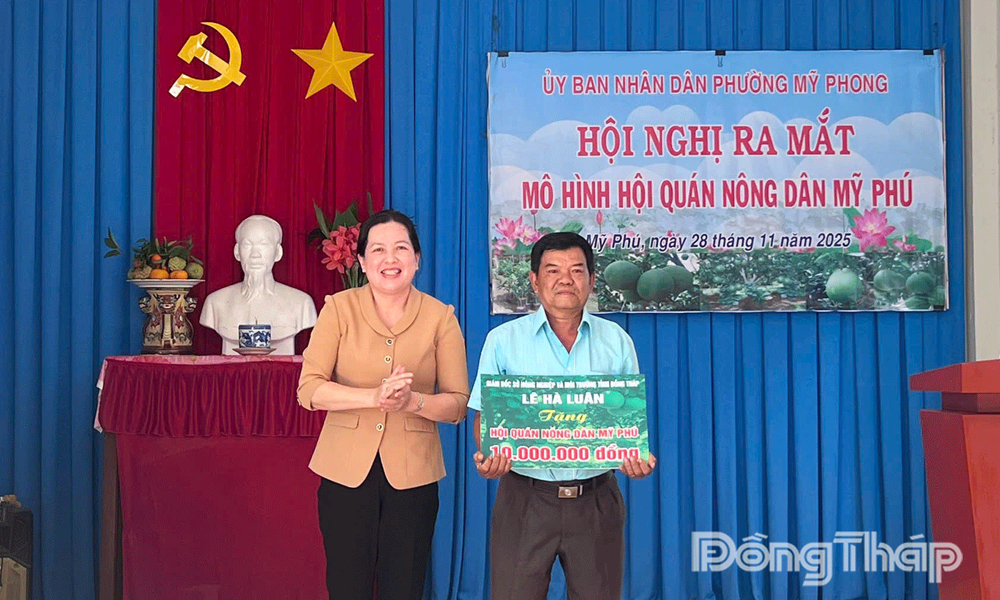 đồng chí Trần Thị Bé Bảy, Phó Giám đốc Sở Nông nghiệp và Môi trường tỉnh trao  kinh phí hỗ trợ cho Hội quán nông dân Mỹ Phú